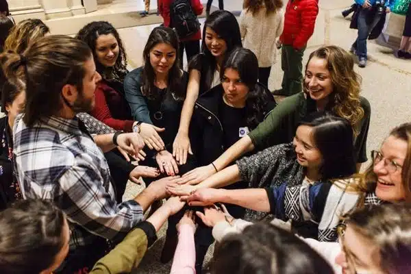 Group in huddle putting hands in center